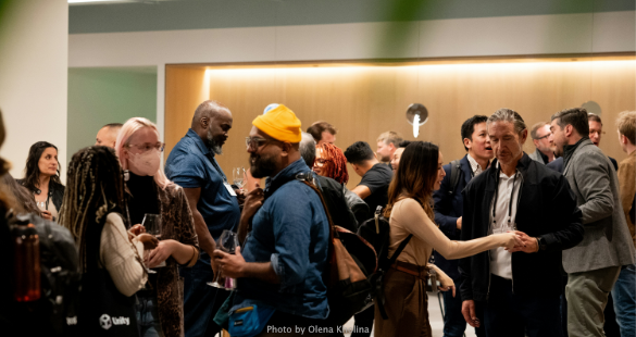 Professionals speaking in small groups at a business networking event.