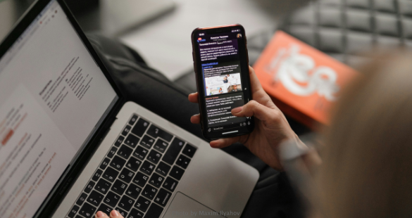 Employee using a smartphone while signing in on a laptop